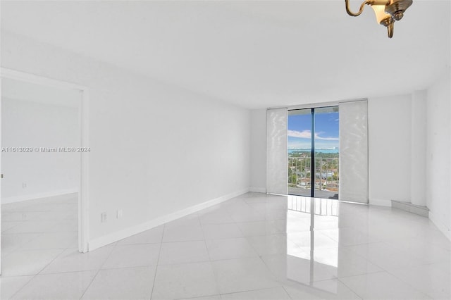 tiled empty room featuring expansive windows