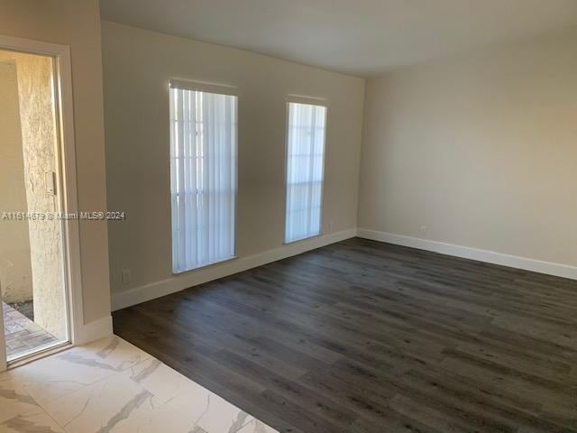 empty room with dark hardwood / wood-style flooring