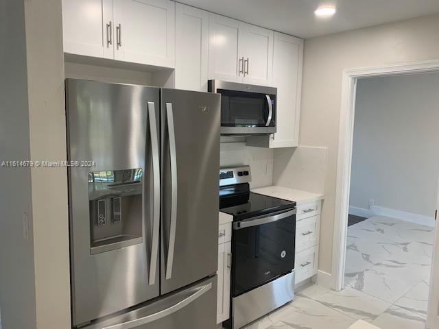 kitchen with appliances with stainless steel finishes and white cabinetry