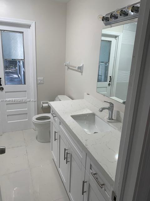 bathroom featuring toilet and vanity