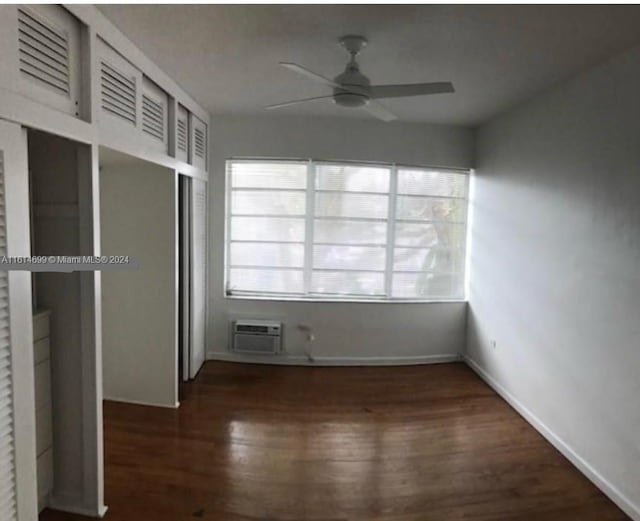 unfurnished bedroom with dark hardwood / wood-style floors, a wall unit AC, ceiling fan, and a closet