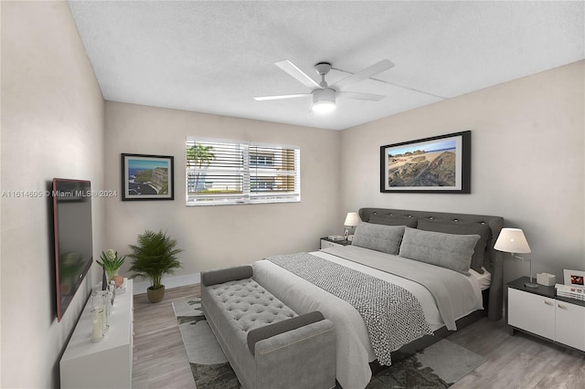 bedroom featuring wood-type flooring, ceiling fan, and a textured ceiling