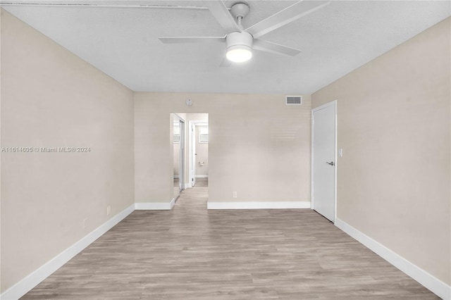 unfurnished room with light hardwood / wood-style floors, ceiling fan, and a textured ceiling