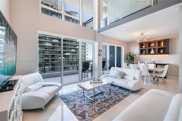 living room with tile patterned flooring, a high ceiling, and an inviting chandelier