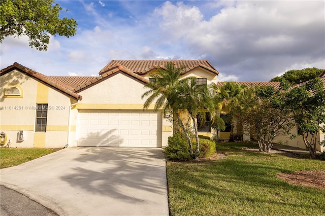 mediterranean / spanish-style house featuring a garage and a front yard