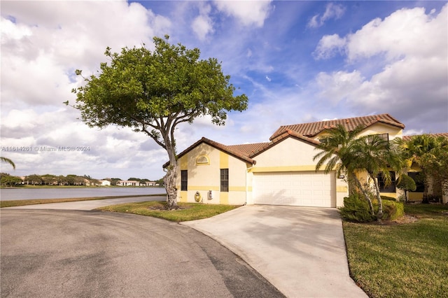 mediterranean / spanish-style house with a garage and a front yard