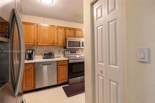 kitchen with a textured ceiling and stainless steel appliances