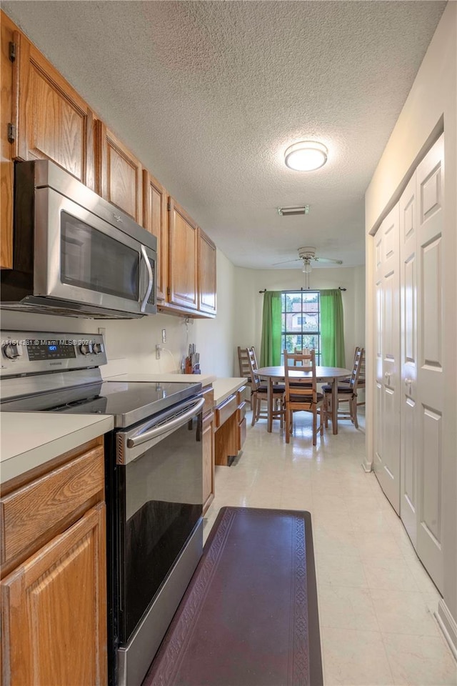 kitchen with a textured ceiling and stainless steel appliances