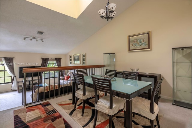 dining room with light colored carpet and high vaulted ceiling