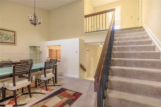 stairway featuring carpet flooring and an inviting chandelier