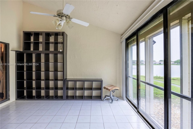 unfurnished sunroom featuring a water view, plenty of natural light, lofted ceiling, and ceiling fan