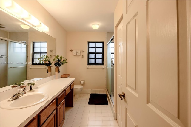 bathroom with tile patterned floors, vanity, an enclosed shower, and toilet