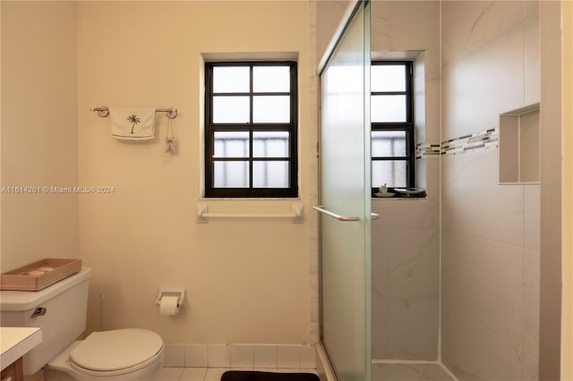 bathroom with tile patterned floors, vanity, toilet, and a shower with door