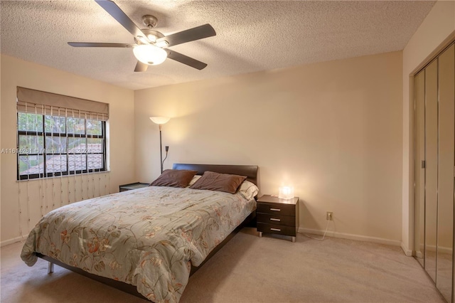 carpeted bedroom with a textured ceiling, a closet, and ceiling fan