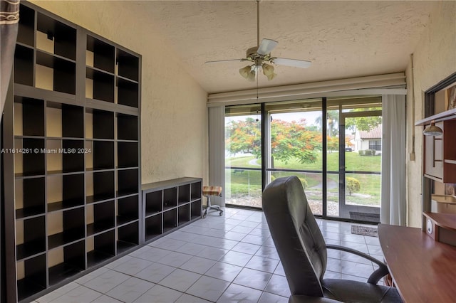 unfurnished office featuring ceiling fan, tile patterned flooring, and a textured ceiling