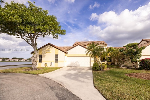 mediterranean / spanish-style house featuring a front yard and a garage