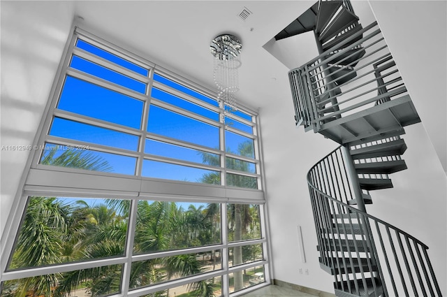 staircase with a high ceiling and a chandelier