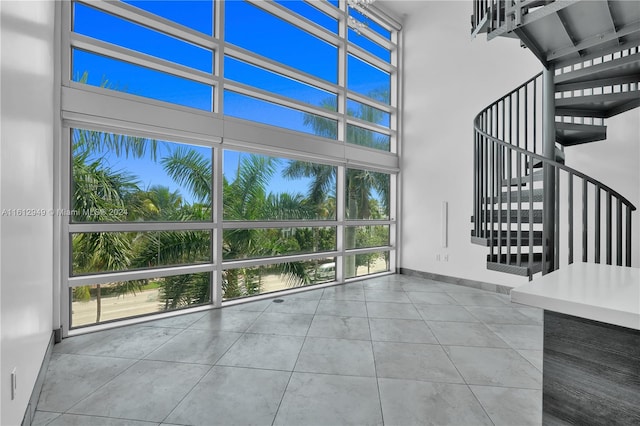 interior space with a high ceiling and light tile flooring