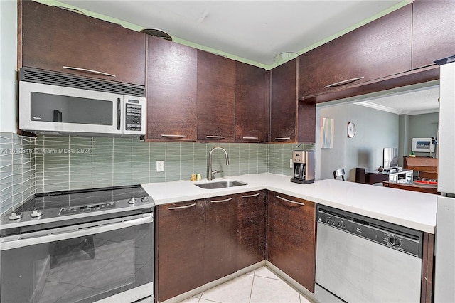 kitchen featuring appliances with stainless steel finishes, tasteful backsplash, light tile patterned floors, dark brown cabinets, and sink