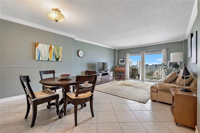 dining area with light tile patterned floors, a textured ceiling, and ornamental molding