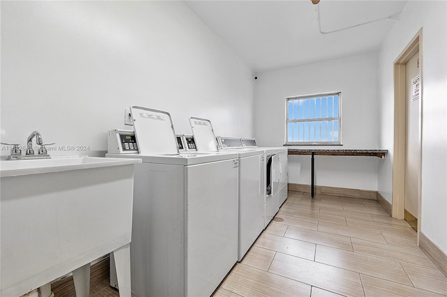 clothes washing area featuring separate washer and dryer and sink