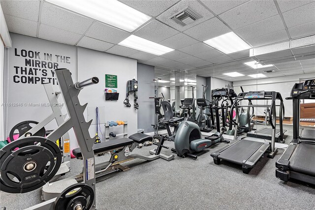 gym featuring a drop ceiling and carpet flooring