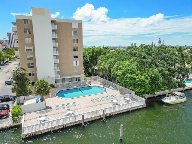 view of pool featuring a water view and a patio area