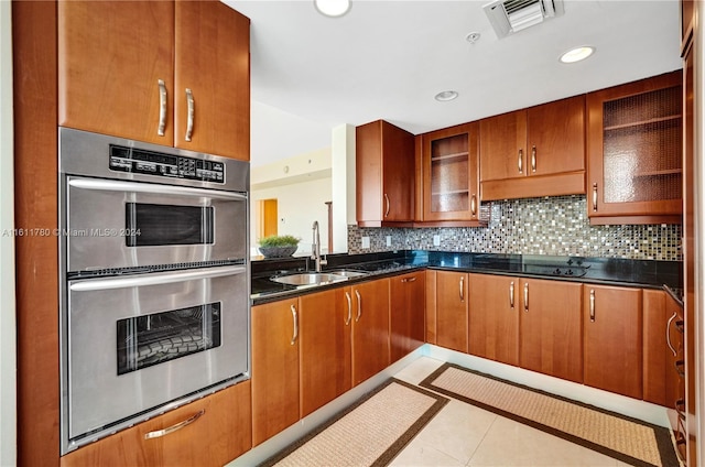 kitchen with backsplash, double oven, sink, light tile patterned floors, and black stovetop