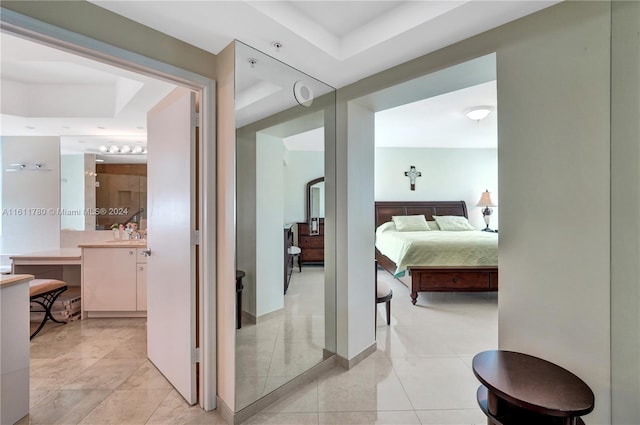 bedroom featuring a raised ceiling and light tile patterned floors