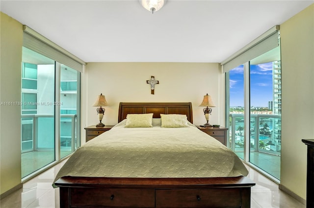 bedroom featuring light tile patterned flooring, a wall of windows, access to outside, and multiple windows