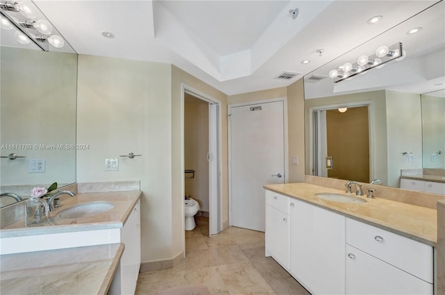 bathroom with vanity, a raised ceiling, and a bidet