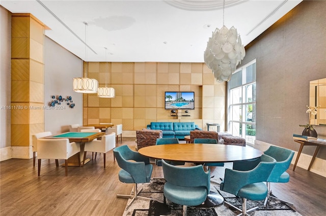 dining space featuring a high ceiling and hardwood / wood-style flooring