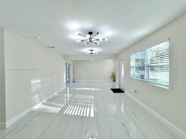 spare room with a chandelier