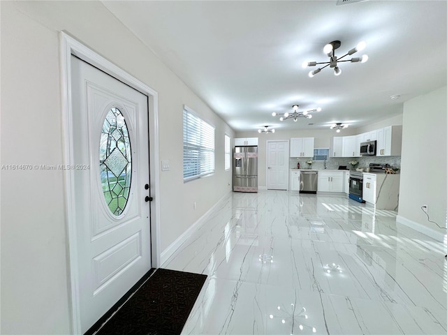 foyer entrance with a notable chandelier