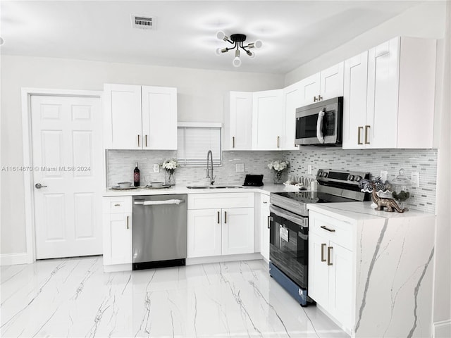 kitchen featuring white cabinets, appliances with stainless steel finishes, backsplash, and sink