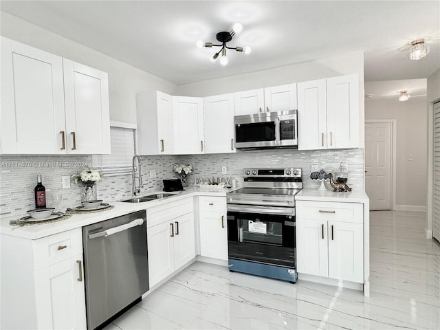 kitchen with white cabinetry, appliances with stainless steel finishes, tasteful backsplash, and sink