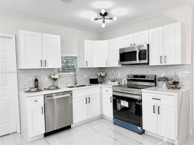 kitchen featuring white cabinets, appliances with stainless steel finishes, sink, and tasteful backsplash