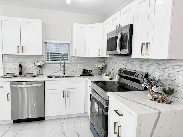 kitchen with white cabinets, stainless steel appliances, backsplash, and sink