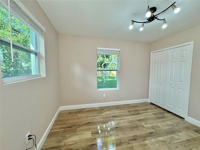 unfurnished bedroom with light wood-type flooring and a closet