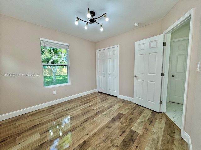 unfurnished bedroom with light hardwood / wood-style floors and a closet