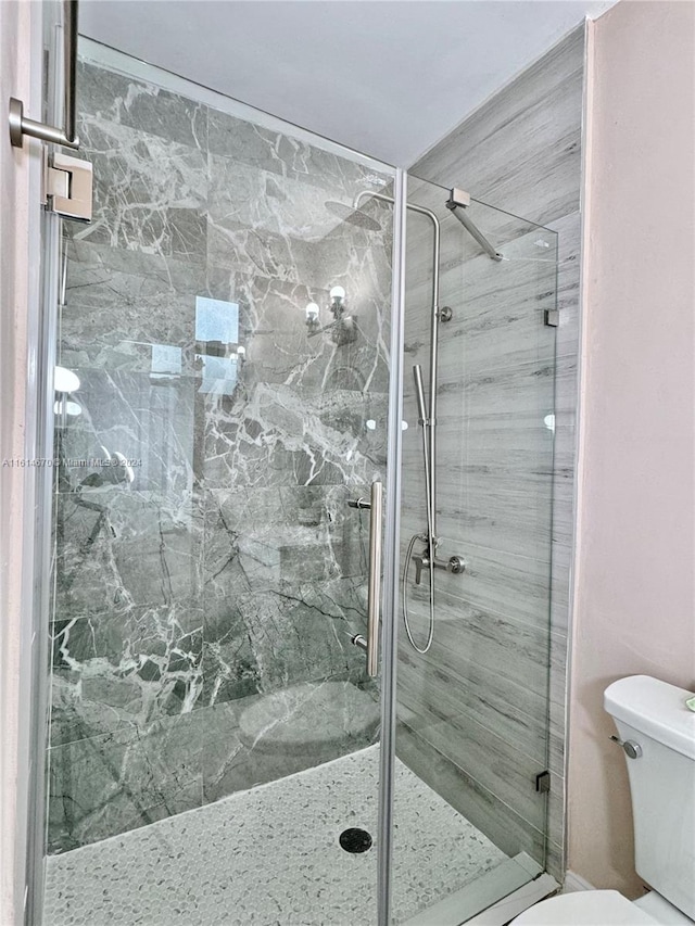 bathroom featuring toilet and an enclosed shower