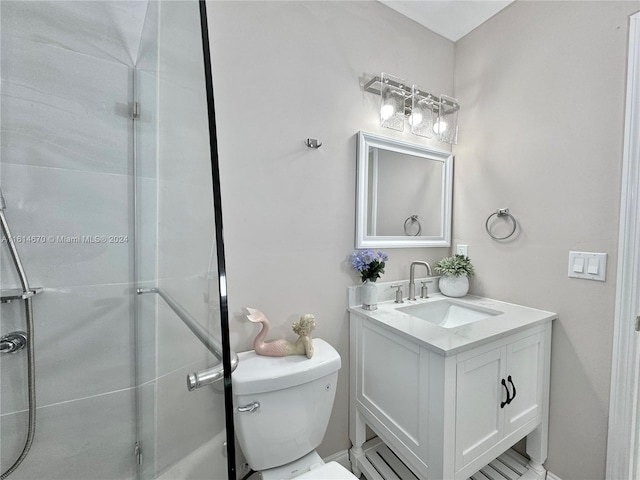 bathroom featuring vanity, toilet, and a shower with door