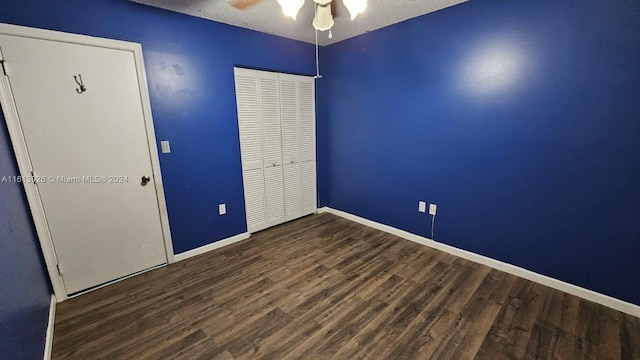 empty room with ceiling fan, wood-type flooring, and a textured ceiling