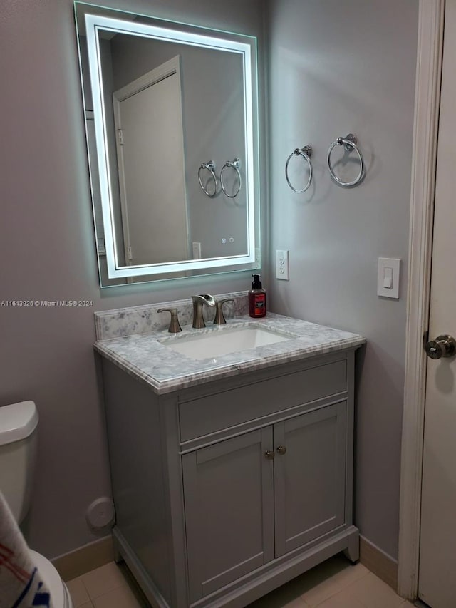 bathroom featuring vanity, tile patterned floors, and toilet