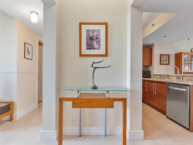 kitchen featuring light hardwood / wood-style flooring, dishwasher, tasteful backsplash, and sink