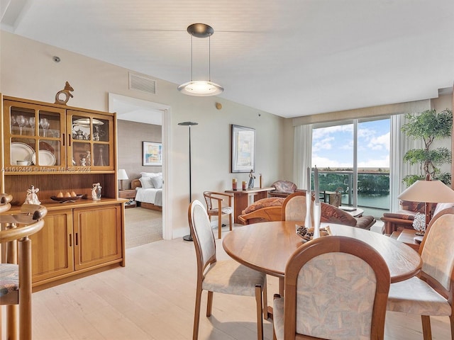 dining room featuring a water view and light wood-type flooring