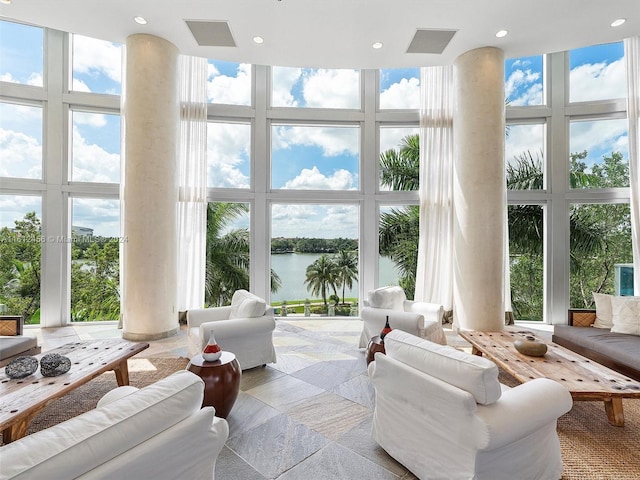 sunroom with plenty of natural light and a water view