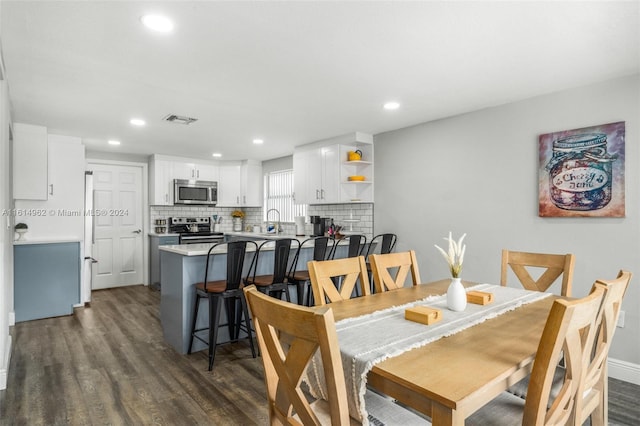 dining area with sink and dark wood-type flooring