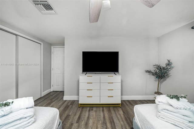 bedroom with ceiling fan, a closet, and dark wood-type flooring