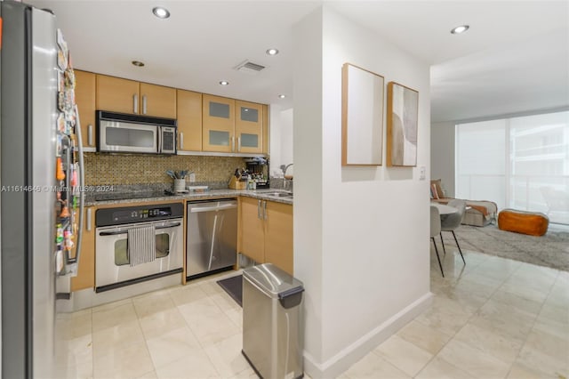 2101 Brickell Ave Unit 2009, Miami, FL 33129 - kitchen with appliances with stainless steel finishes, light stone counters, backsplash, glass insert cabinets, and a sink